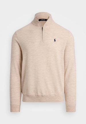 Beige genser med kvart glidelås og lange ermer, ribbestrikkede mansjetter, og brodert navyblå polo-spillerlogo på venstre bryst.