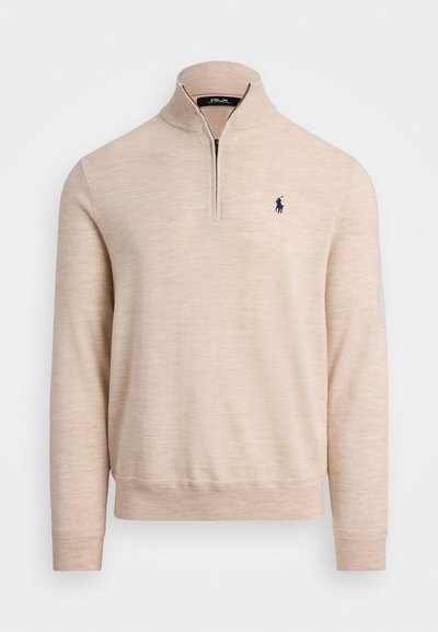 Pull en beige à fermeture éclair quart, avec des manches longues, des poignets côtelés et un logo de joueur de polo brodé en bleu marine sur la poitrine gauche.