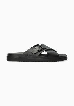 Sandale noire en cuir à enfiler avec des brides croisées, une boucle métallique et une semelle texturée, portant la marque "Mephisto" sur le côté.