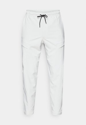 Białe spodnie dresowe z elastycznym pasem i czarnym sznurkiem. Posiada boczne kieszenie oraz zwężane nogawki dla dopasowanego wyglądu.