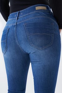 Jeans de mezclilla en azul oscuro con una textura suave, que cuentan con dos bolsillos traseros y costuras contrastantes en las costuras. Etiqueta de cuero marrón claro en la cintura.