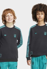 Felpe nere con strisce turchesi e loghi ricamati. Design a girocollo, con polsini e orlo a costine. Pantaloni turchesi coordinati.