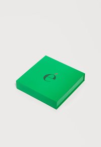 Πράσινο τετράγωνο κουτί με στιλιζαρισμένο μαύρο πεζό γράμμα "e" και μικρή κόκκινη διακριτική λεπτομέρεια πάνω σε λευκή απλή επιφάνεια.