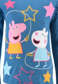 Blue long-sleeve shirt featuring cartoon characters with pink and white accents, surrounded by colorful stars in pink, yellow, and blue.