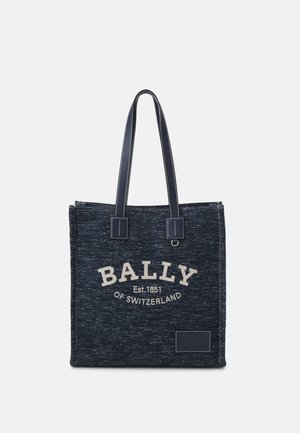 Sac fourre-tout en tissu bleu foncé avec deux longues poignées et texte blanc "BALLY Est. 1851 OF SWITZERLAND" sur le devant.