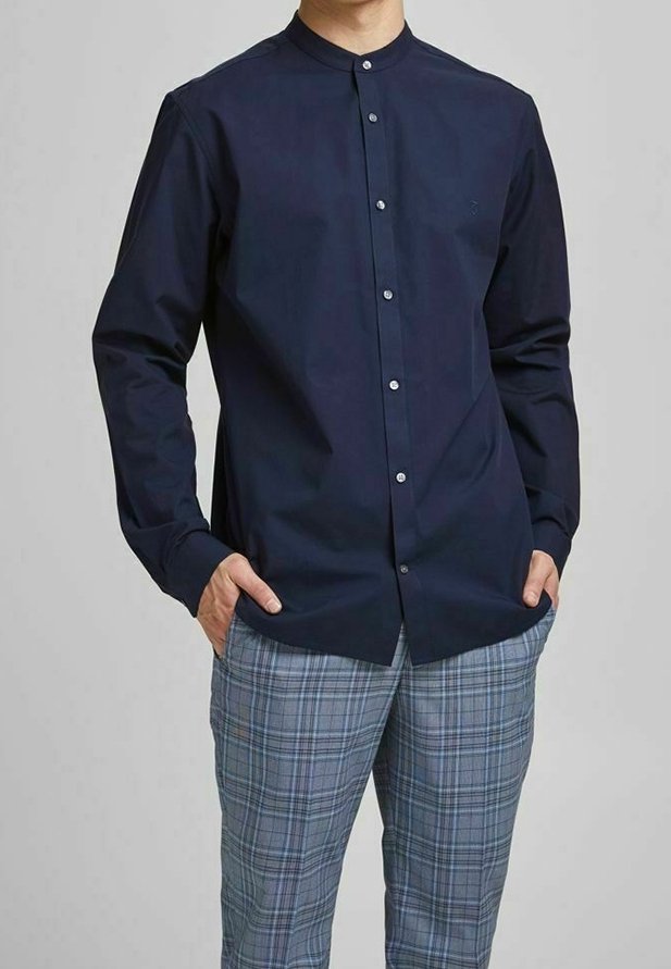 Camicia a maniche lunghe blu navy con colletto alla coreana, dotata di bottoni bianchi e vestibilità slim. Abbinata a pantaloni scozzesi azzurri chiari.