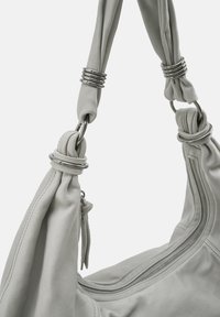 Sac à main en cuir gris clair avec une large bandoulière, des éléments métalliques et un détail zippé. Matière douce et texturée avec des accents noués.