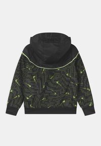 Černá bunda s kapucí, zdobená geometrickým vzorem v zelené a bílé barvě. Vyrobena z lehkého materiálu, s elastickými manžetami a lemem pro těsné usazení.