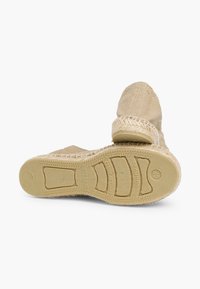 Beige geweven schoenen met een bovenwerk van textuurstof, ronde neus en gevlochten jute accenten. Rubberen zool met een patroon voor grip.
