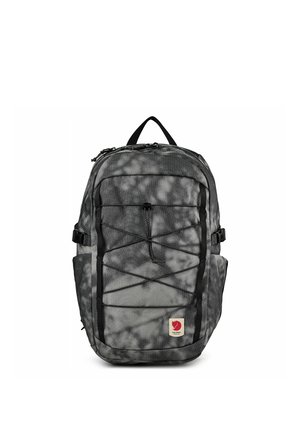 Sac à dos marbré gris et noir avec cordons élastiques à l'avant, poches latérales, poignée supérieure et petit patch logo rouge en bas à l'avant.