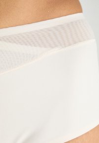 White seamless underwear featuring a textured mesh waistband, smooth fabric, and a minimalist design with a clean finish.