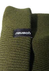 Green knitted beanie with a textured pattern and a black tag bearing the brand name "Reusch." The fabric appears soft and warm.