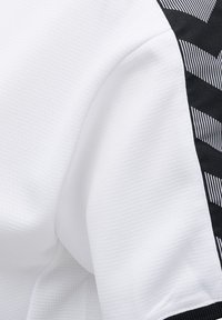 Hvid sportsjersey med tekstureret stof, der har et sort sidepanel med et geometrisk mønster og vandrette striber.