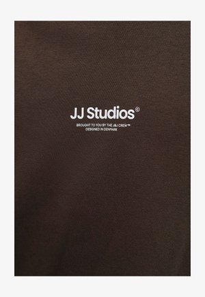 Valge "JJ Studios" logo koos tekstiga „Toimetanud J&J meeskond, disainitud Taanis“ pruuni kangatausta peal.