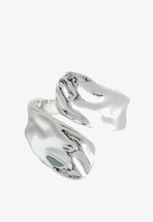 Close-up of a polished silver open ring with an organic, uneven, and wavy surface design.
