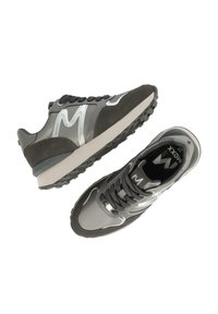 Sneaker grigie con tomaia in suede e materiale sintetico lucido, punta rotonda, suola spessa grigia e distintivo logo 'M' sul lato. Presentano una chiusura con lacci.
