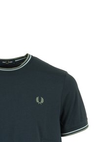 T-shirt navy a maniche corte con scollo a girocollo, caratterizzato da dettagli a righe verdi e bianche sul colletto e sulle maniche, e un piccolo logo.