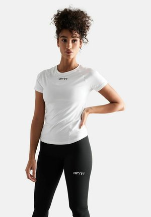 White short-sleeve athletic shirt with a round neckline and logo, paired with black leggings featuring logo detail. Smooth fabric, fitted design.