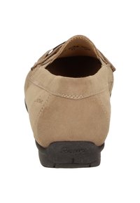 Chaussure en daim beige avec un talon arrondi, une semelle en caoutchouc et des détails de couture. L'intérieur est sombre, montrant une doublure douce et moelleuse.