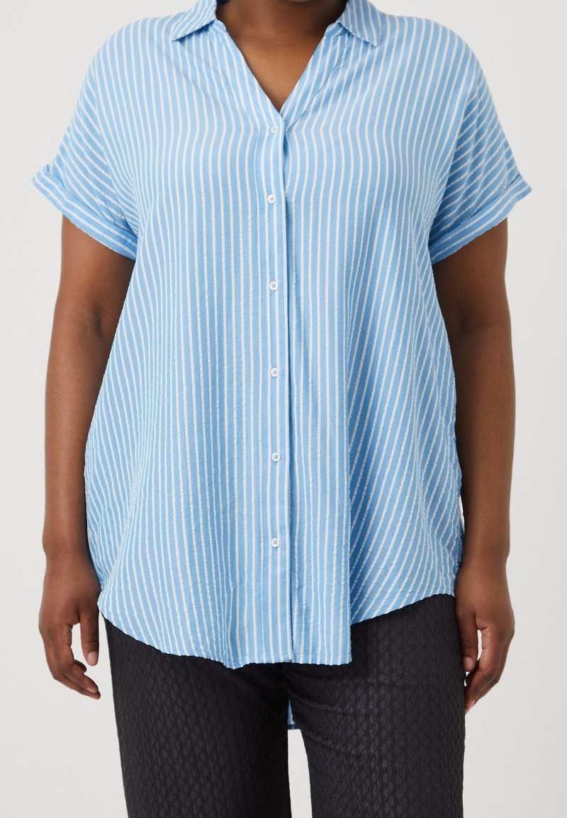 Ljust blå kortärmad skjorta med vita vertikala ränder, med krage och knappframsida. Tyget verkar mjukt och lättviktigt.