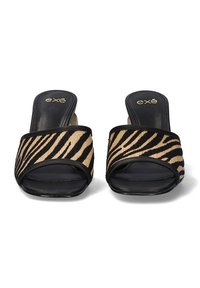 Chanclas deslizantes con estampado de cebra en negro y beige, con una amplia correa de tela, punta abierta y una suela negra lisa. Marca en la plantilla.