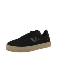 Black sneaker made of suede with a textured rubber sole. Features a reflective logo and black laces, designed with a low-top silhouette.