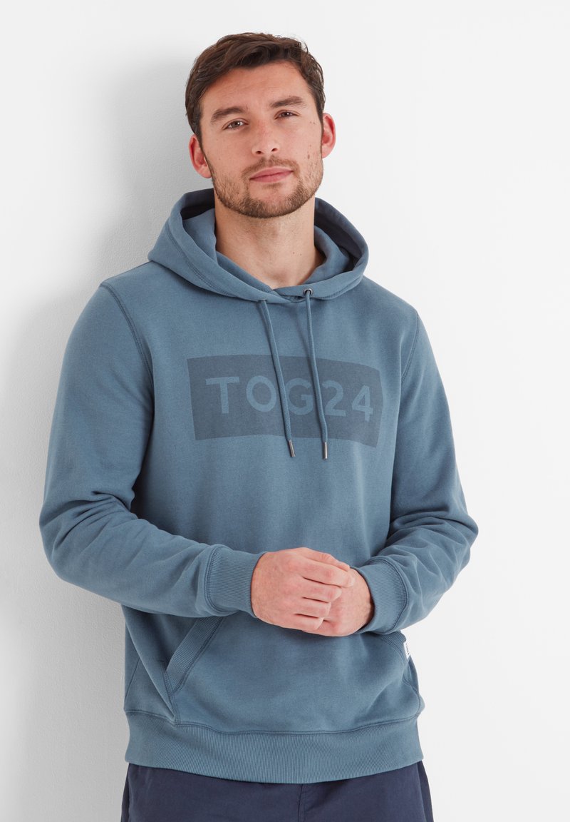 Hooded sweatshirt in teal blue, featuring a large dark block with "TOG24" printed. Made from soft material with ribbed cuffs and hem.