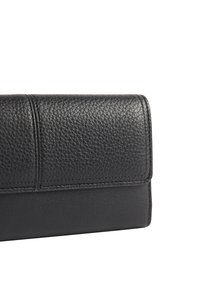 Czarny skórzany portfel o fakturze kamyków, z gładką dolną częścią i delikatnym szwem wzdłuż krawędzi.