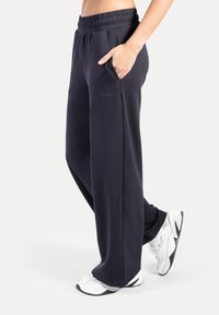 Marineblauwe sweatpants met een ontspannen pasvorm, elastische tailleband, zijzakken en subtiele logo-borduring in een bijpassende kleur.