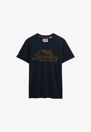 T-shirt di cotone blu navy con maniche corte e collo rotondo, con logo ad ali d'oro e testo 'Superdry' sulla parte anteriore.