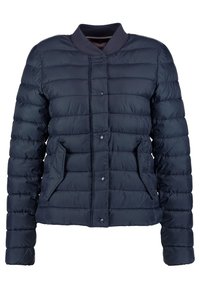Giacca puffer trapuntata di colore blu navy con chiusura a bottoni a pressione, colletto a costine e due tasche frontali angolate.