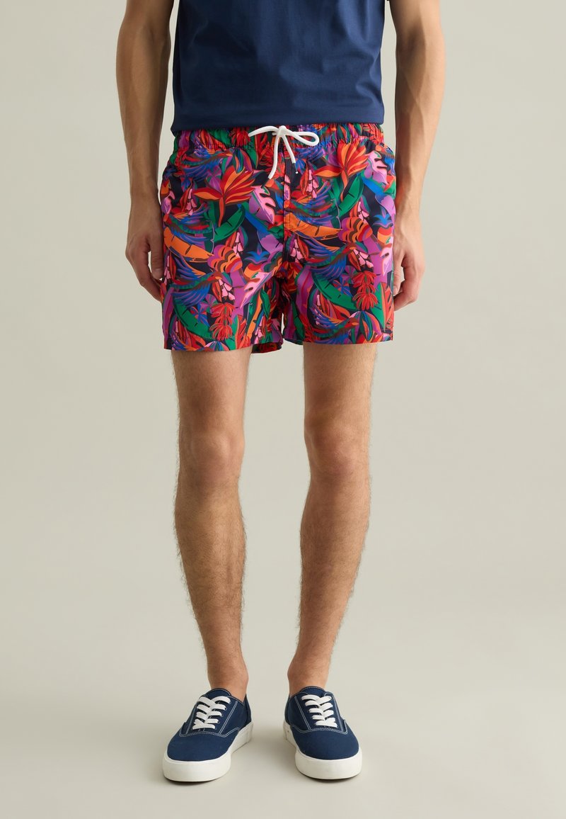 Bermudas de baño para hombre con estampado floral multicolor, con cintura ajustable, material liviano y corte estándar, combinadas con обувь azul marino.