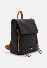 Sac à dos en cuir noir avec un rabat, accents beiges, deux poches zippées et courtes sangles en cuir. Surface texturée avec des coutures détaillées.