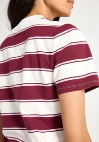 Kortærmet polo shirt med maroon og hvide vandrette striber, lavet af blødt bomuldsmateriale og med detaljeret klassisk krave.