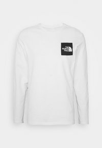 Langärmliges weißes T-Shirt aus Baumwolle. Mit einem schwarzen Quadratgrafik auf der Brust, das das "The North Face"-Logo in Weiß zeigt.