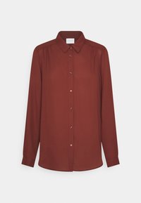 Chemise à manches longues boutonnée de couleur rouille profonde, avec un col, des boutons sur le devant et de légers plis aux épaules. Texture de tissu lisse.