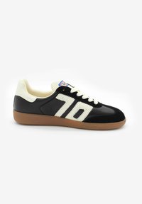 Czarno-kremowe buty sportowe z materiałów zamszowych i skórzanych, z paskowanym wzorem i teksturowaną gumową podeszwą. Numer '70' po boku.