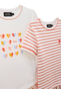 Deux T-shirts : un blanc uni avec des motifs de cœurs multicolores et le texte "amour", et un rose rayé avec une petite touche de cœur.