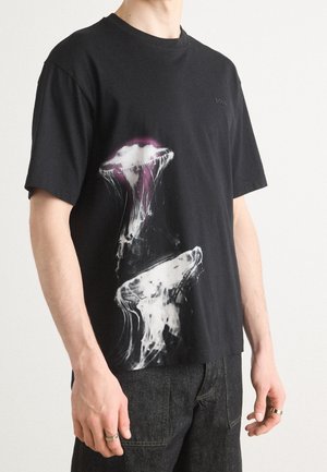 Czarna bawełniana koszulka z białym i fioletowym motywem meduzy na froncie. Projekt z okrągłym dekoltem, krótkimi rękawami oraz luźnym krojem.