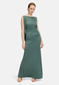Maxikleid aus einem gedämpften grünen Stoff, mit einer figurbetonten Passform, Rundhalsausschnitt und seitlichen Drapierungsdetails. Glatte Textur, ärmelloser Stil.