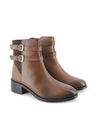 Botas de tobillo de cuero marrón con un acabado suave, que presentan dos correas exteriores con hebillas doradas, un tacón bajo y paneles elásticos laterales.