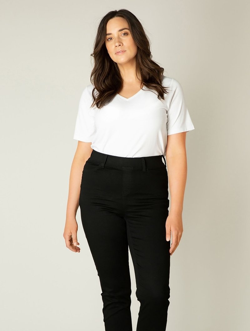 Witte V-hals T-shirt gecombineerd met zwarte slim-fit broek. Het T-shirt heeft korte mouwen; de broek heeft een standaard taille en een nette afwerking.