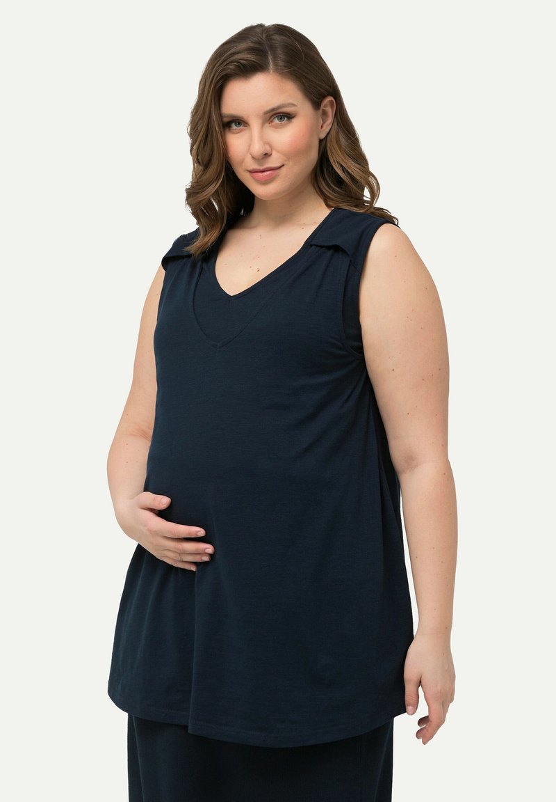 Granatowy, bezrękawnik z dekoltem w serek i delikatnymi fałdami przy ramionach, wykonany z gładkiego materiału, z luźnym krojem zapewniającym komfort.