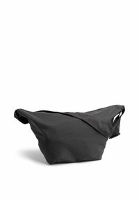 Juodas audinio krepšys su išlenktu pavidalu, viengungiu peties dirželiu ir užtrauktuku. Pasižymi minimalizmo dizainu ir tekstūruota paviršiumi.