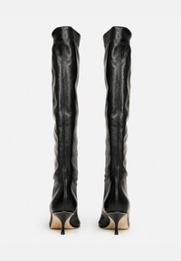 Botas de cuero negro por encima de la rodilla con un diseño elegante, punta afilada y tacones de aguja delgados. Textura suave y forma ajustada.