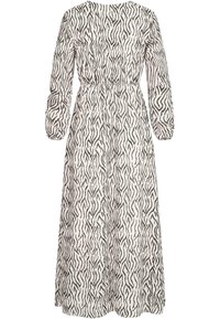 Robe maxi blanche avec un imprimé zèbre abstrait noir. Elle présente des manches longues bouffantes et une taille cintrée pour un look décontracté. Tissu léger.