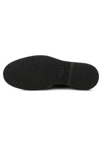 Suela de zapato de goma negra con patrón de agarre texturizado y logotipo "STB" en relieve. Presenta una forma amplia y redondeada para mayor estabilidad.