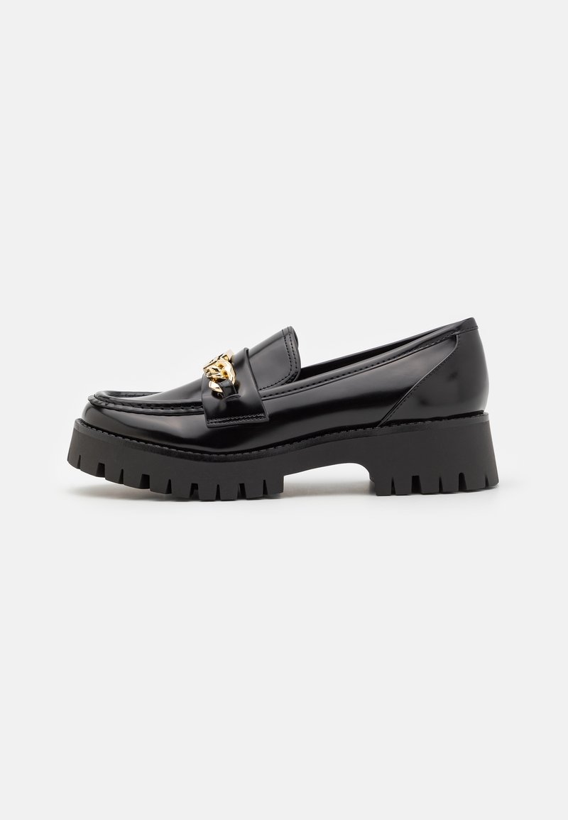 Mocassin noir brillant avec semelle chunky et détail en chaîne dorée sur le dessus, présenté en profil latéral sur un fond blanc.