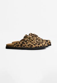 Leopard print slip-on clogs made of suede, with a cork footbed, black rubber sole, and a gold buckle accent on the strap.
