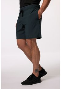 Tmavě modré plavky s elastickým pasem a stahovací šňůrou, obsahující boční kapsy a logo na nohavici. Materiál vypadá lehce.